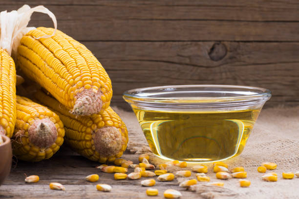 istock Corn oil in glass bowl with dried corn groats and kernels on rustic backdrop. Cooking oil composition 1214525164