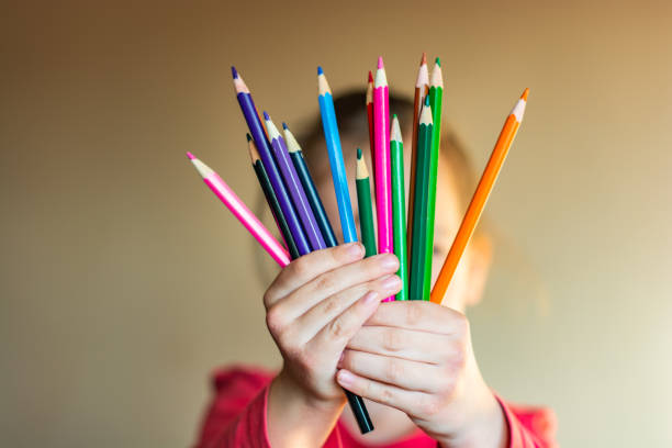 mała ręka trzymająca kolorowe ołówki - variegated close up textured sharp zdjęcia i obrazy z banku zdjęć
