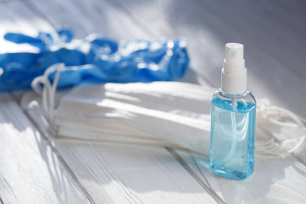 istock Hand sanitizer antibacterial antiseptic gel, face mask on table 1214525977
