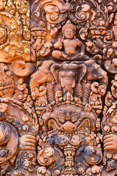dios indra sentado en el alivio de elefantes de tres cabezas del templo banteay srei en angkor - demon statue ancient architecture fotografías e imágenes de stock