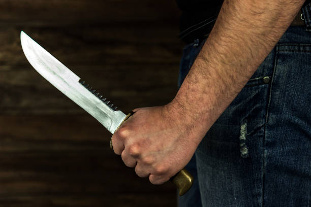 istock man with a knife in his hand in the dark 1214526786