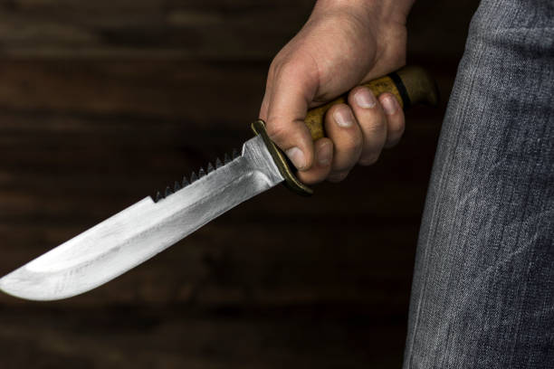 istock man with a knife in his hand in the dark 1214526803