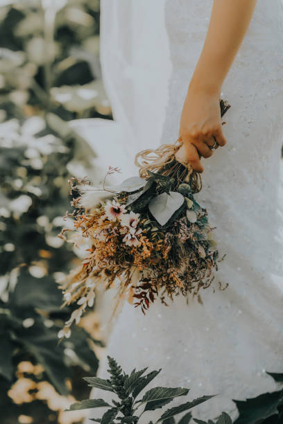 istock The bride and the flowers in her hand 1214529725