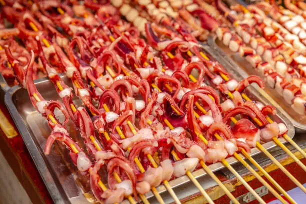 This pic shows Asian stick street food on skewers.meat and other street food ready to grill can be seen in the pic. The pic is taken in november 2019.