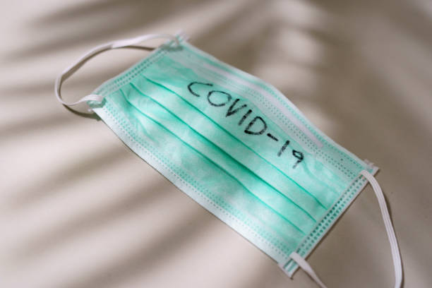 istock Surgical mask with COVID-19 text written on Mask. 1214533802