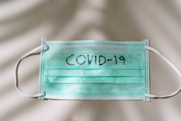 istock Surgical mask with COVID-19 text written on Mask. 1214535475