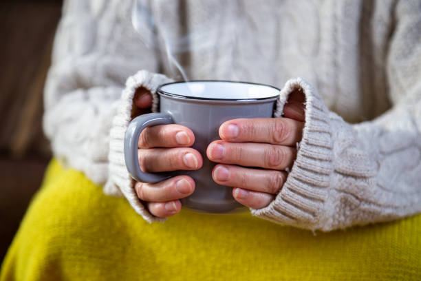 istock hands holding a mug with hot drink comfortably at home 1214535680