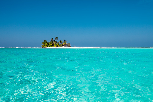 tiny little sandy island with palm tree and white sand beach in the turquoise lagoon of Cocos Keeling atollm landscapephotography
