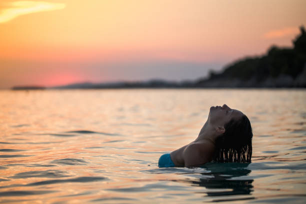 istock Sunset on the beach and a beautiful lady 1214537405