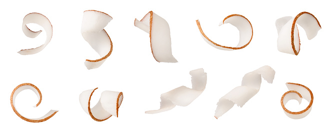 Las virutas de coco se curvan en trozos aislados sobre fondo blanco como detalle de diseño del paquete photo
