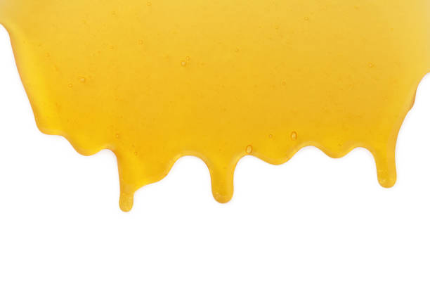 istock Yellow honey liquid drops flow from above isolated on white background 1214537738