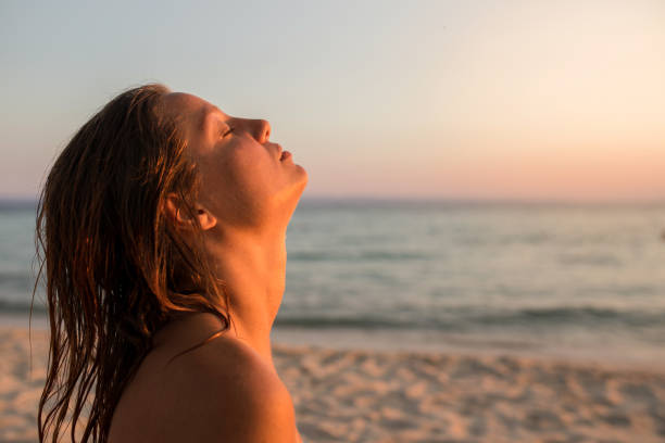 istock Sunset on the beach and a beautiful lady 1214538386