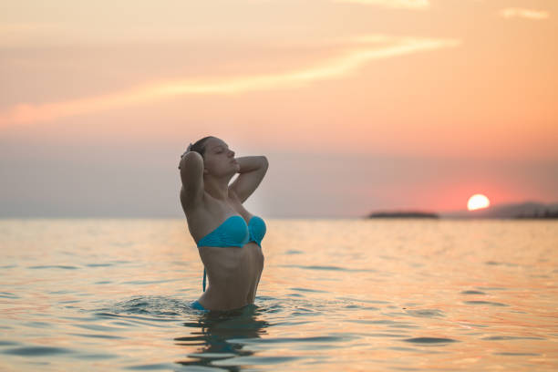 istock Sunset on the beach and a beautiful lady 1214538619