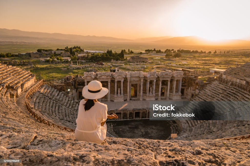 Hierapolis ancient city Pamukkale Turkey, young woman with hat watching sunset by the ruins Unesco Turkey, Hierapolis ancient city Pamukkale Turkey, young woman with hat watching sunset by the ruins Unesco Hierapolis Stock Photo