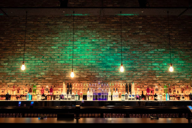 Stylish Bar Wide angle shot of a bar counter and shelves of alcohol behind the bar. brick photos stock pictures, royalty-free photos & images