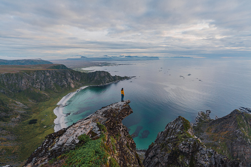 Young Caucasian woman  standing with view on beach on Lofoten island