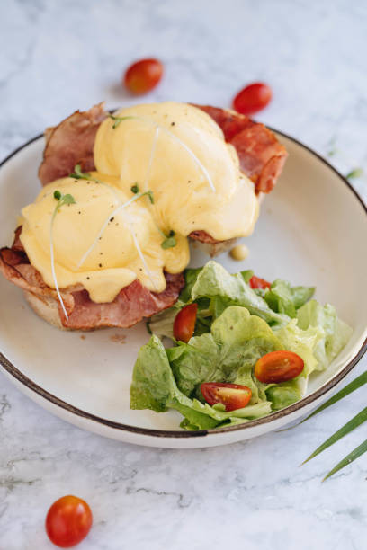 istock benedict egg with bacon and salad on the white plate 1214545027