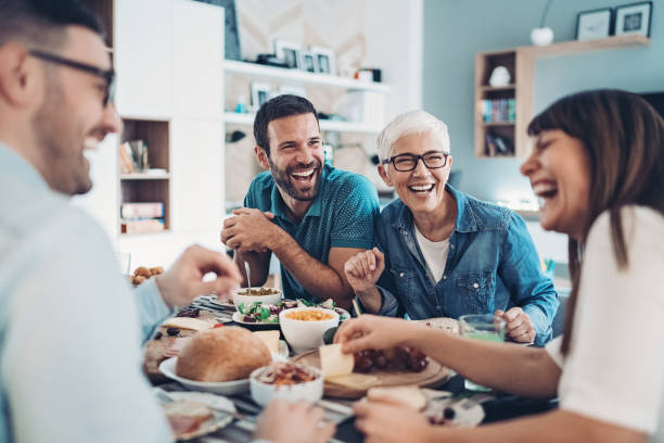 Having the best time together Multi-generation family eating together friends laughing stock pictures, royalty-free photos & images