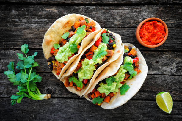 Vegan tacos with black beans, sweet potato and guacamole and tortillas flatbread Homemade vegan tacos with black beans, sweet potato and guacamole and tortillas flatbread. Clean eating, plant based food concept. Top view tacos stock pictures, royalty-free photos & images