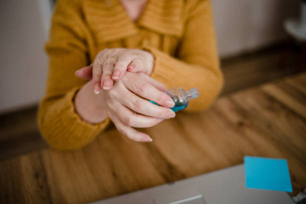 istock An older woman disinfects her hands 1214555097