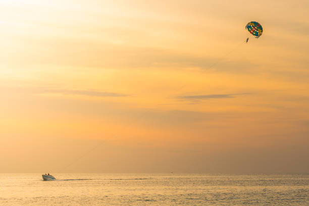 istock Tourists para-sailing in sunset time at Phuket Beach, Thailand 1214556905