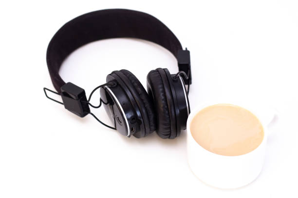 istock black headphones with a cup of coffee on a white background. 1214557272