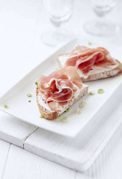 istock Sandwich with soft cheese and ham. Bright wooden background. 1214557319
