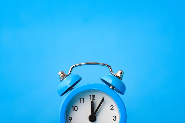 Fragment of an alarm clock and empty space above it, blue background stock photo