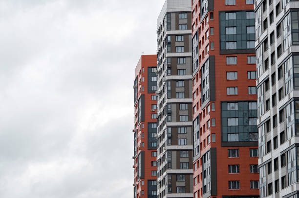 istock A row of modern colored multi- storey buildings against a cloudy sky. Background 1214558394