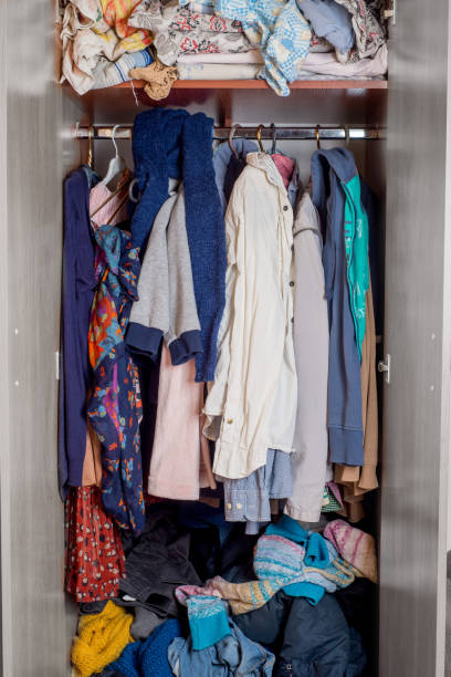 istock open wardrobe with clothes on hangers and clutter in open drawers 1214559493