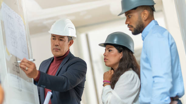 istock Architect explaining details of a blueprint to house owners 1214560504