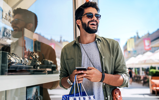 Modern young man enjoying in shopping. Consumerism, fashion, lifestyle concept
