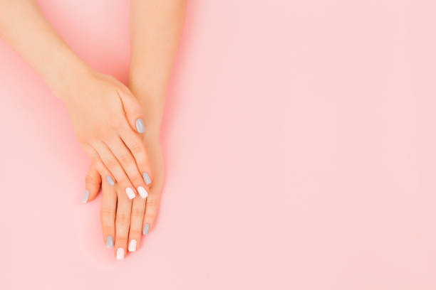 istock Beautiful young woman's hand with perfect grey manicure on pink background. 1214562928