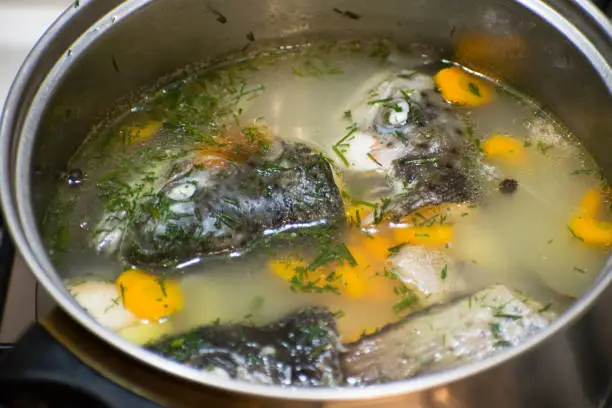 Close up of traditional russian fish soup. Fish soup with trout and vegetables.