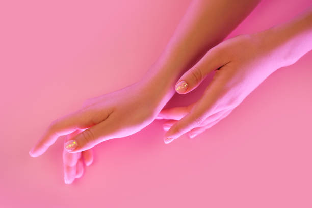 istock Woman's hands with perfect manicure in trendy neon light on pink background. 1214563600
