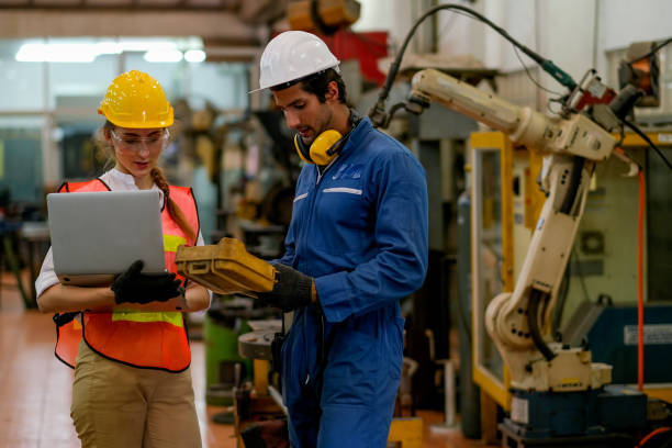 istock Technician or worker man and woman discussion about robot working in factory 1214565264