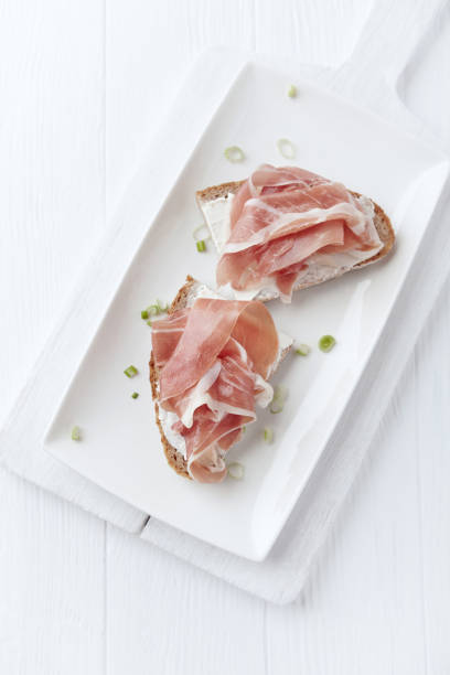 istock Sandwich with soft cheese and ham. Bright wooden background. 1214566938