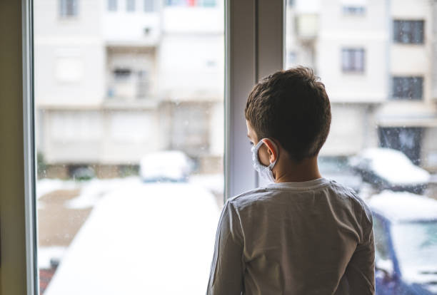 istock Boy wearing anti virus mask staying at home 1214568145