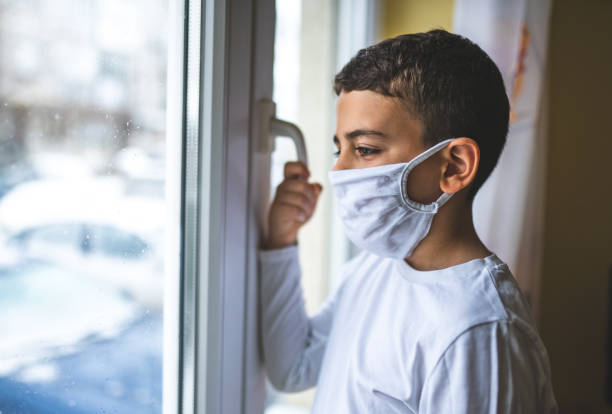 istock Boy wearing anti virus mask staying at home 1214568204