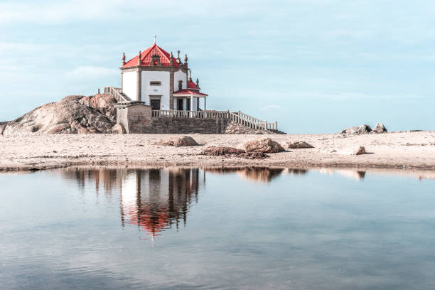 Lonely chapel on the beach reflected in the water, Costa Nova Beach, Aveiro, Portugal, Nov.2019
