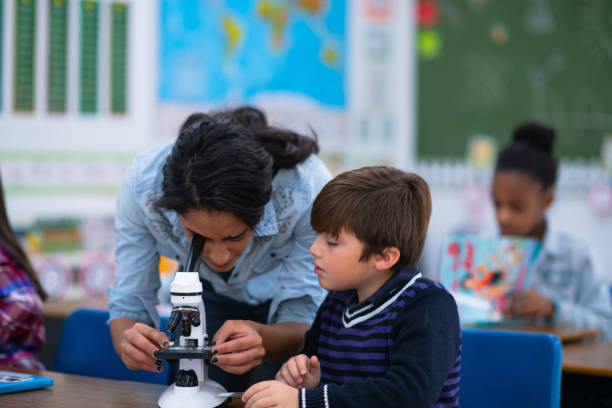 istock Teacher Helping a Student with His Microscope stock photo 1214570092