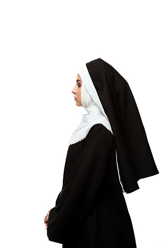 vista lateral de la monja con ropa negra, aislada en blanco photo