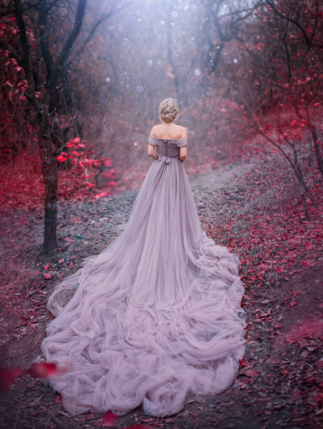 reine de femme de silhouette dans les arbres magiques d’automne d’arbres magiques des feuilles rouges. princesse blonde. robe violette vintage de vêtements médiévaux - fairy forest women magic photos et images de collection