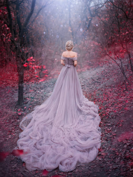 Silhouette woman queen in Autumn forest magic trees red leaves. blonde princess. Medieval clothes vintage purple dress Silhouette woman queen walk in Autumn forest magic trees red leaves. Elegant blonde princess. Royal Medieval clothes vintage evening purple dress long train bare back. backdrop blue shiny mystic fog pink gown stock pictures, royalty-free photos & images