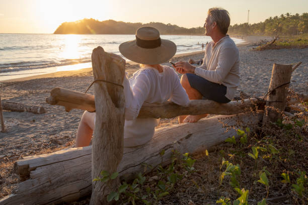 istock Mature couple relax by tropical beach at sunrise 1214579241