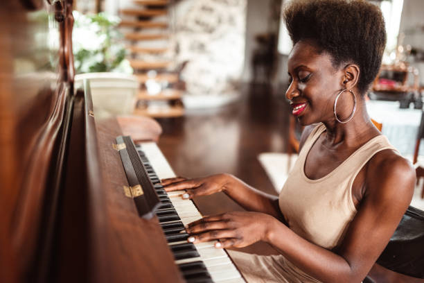 istock afro woman playing piano 1214579471