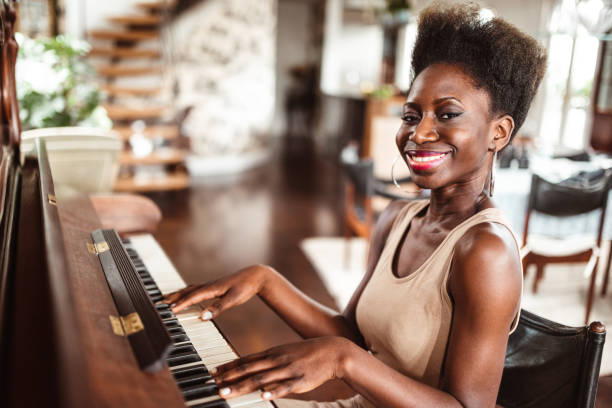 istock afro woman playing piano 1214579503