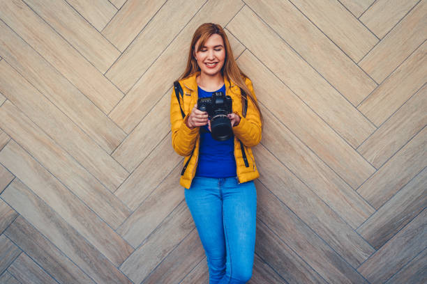 Cheerful caucasian woman with her camera outside
