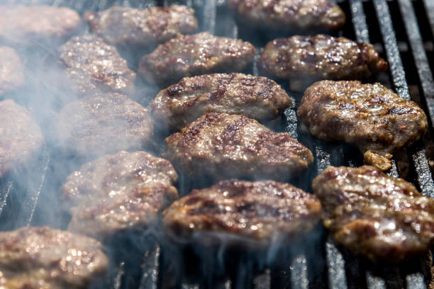 boulettes de viande cuites sur le barbecue avec de la fumée - barbecue grill focus outdoors horizontal photos et images de collection