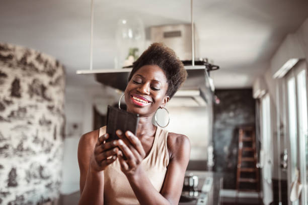 istock afro woman with smartphone at home 1214579957